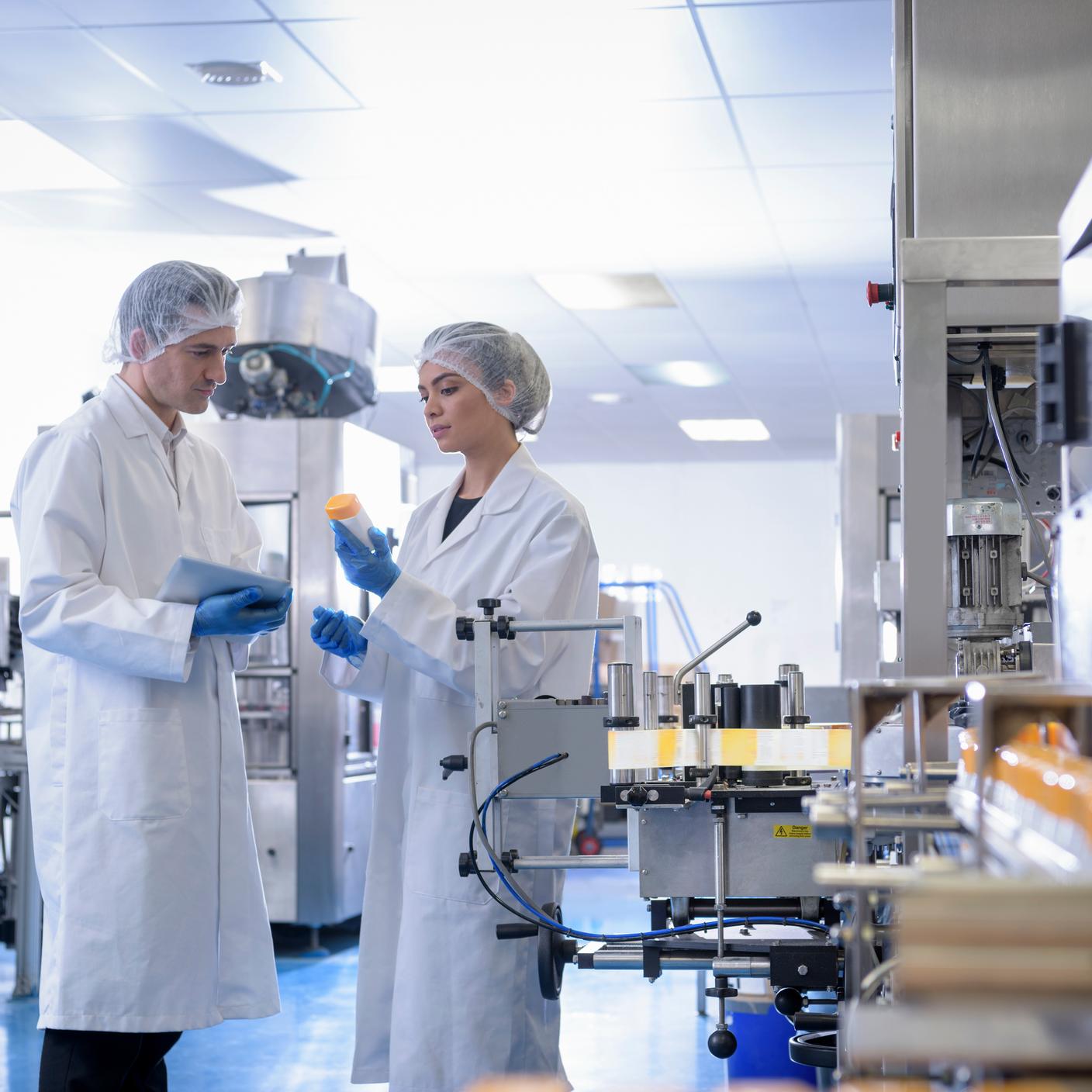 Mitarbeitende inspizieren ein Produkt in einer pharmazeutischen Fabrik